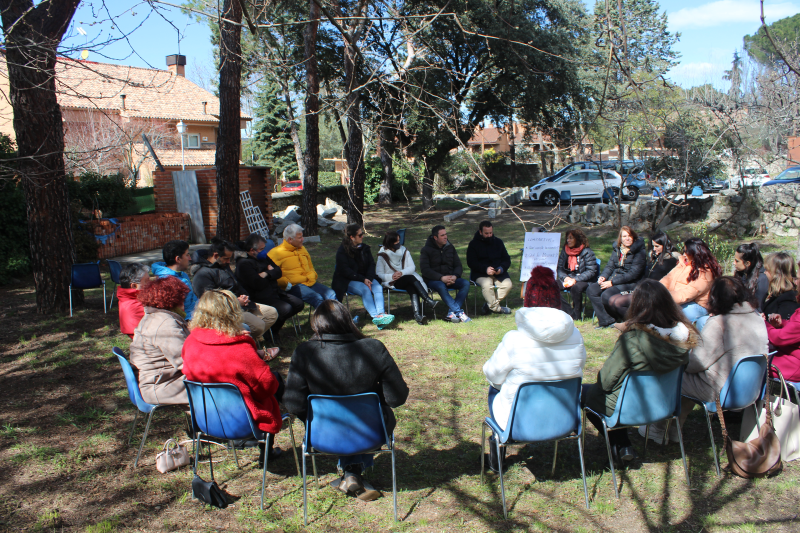 Reunión de personas sentadas formando un circulo en la naturaleza